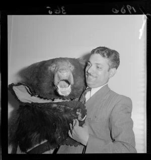 Man holding a bear skin at the Indian Legation, Wellington