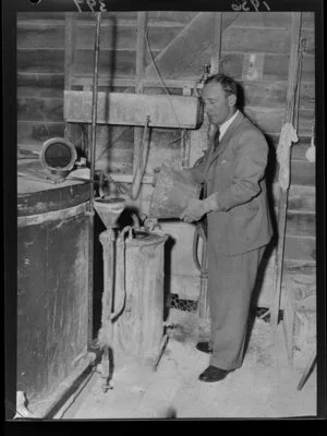 Hugh Beetham pours carbide into the acetylene gas system at Brancepeth Station, Masterton