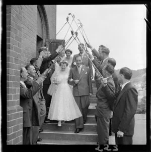 Wedding guests form an arch out of golf clubs as newlywed couples Stout and Dixon leave All Saints Church, Belmont, Lower Hutt