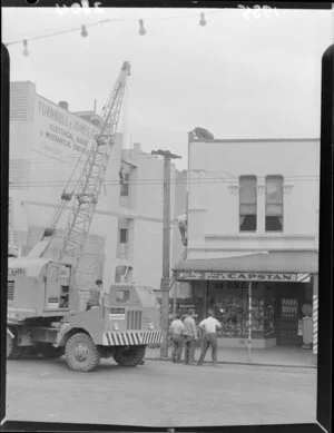 Crack in building above W (Bill) Boffa Tobacconist's shop being investigated, Courtenay Place, Wellington