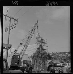 A crane helping the steeple of St Aidan's Church into position, Miramar, Wellington