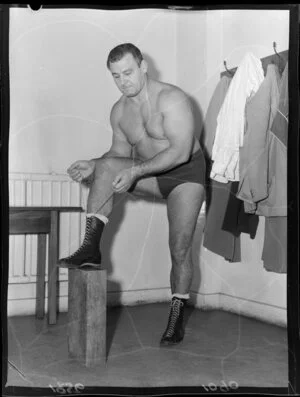 A wrestler lacing his boots, in a changing room at the Wellington Town Hall