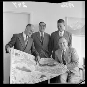 American documentary filmmaker James A Fitzpatrick looks at a map of New Zealand with R S Odell, H Glendinning and D Williams