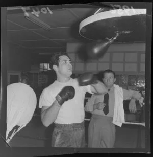 Ricardo Marcos, Australian light heavyweight boxing champion, punching a speed bag, whilst his trainer observes
