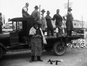 Men, truck and man wearing Maori clothing, probably in Hastings