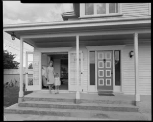 Woman and child standing on steps at entrance to Tait house