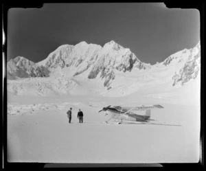 Two men standing next to a Mount Cook Air Services aeroplane at Fox Glacier