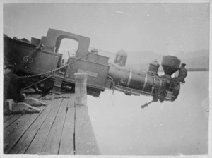 Accident showing steam engine hanging half over the edge of Lyttelton wharf, having been dropped from a crane while being loaded or unloaded