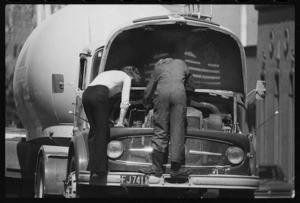 Men working on the engine of a Mercedes tanker