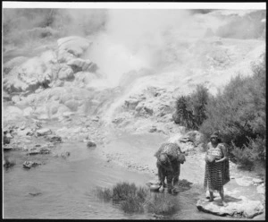 Two unidentified Maori women with gourds by hot pool, possibly in Rotorua