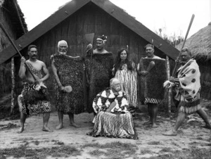 Group outside a whare at the New Zealand International Exhibition in Christchurch