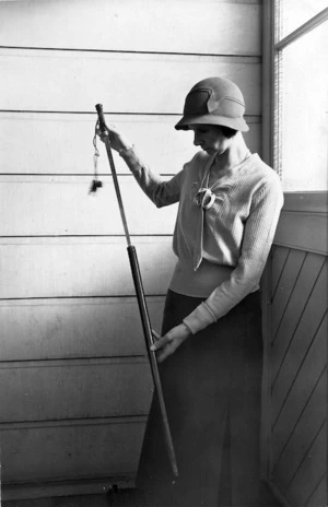 Agnes Isobel Stout holding a sword-stick originally owned by Hongi Hika