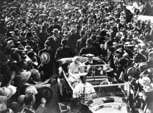 Duke and Duchess of York in a car surrounded by a crowd, during their 1927 visit to New Zealand, location unidentified