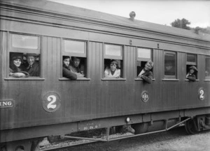 People looking out of the windows of a railway carriage