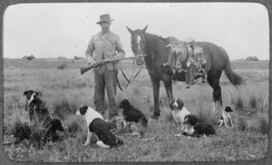 Creator unknown : Photograph of an unidentified hunter with a brace of rabbits, on his horse