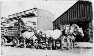 Horse drawn cart of Moller's Carrying Company with the businesses of S Lissamen and G Death in the background, Victoria Street, Kaponga
