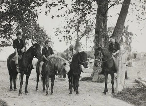 Four schoolchildren sitting on their horses under trees