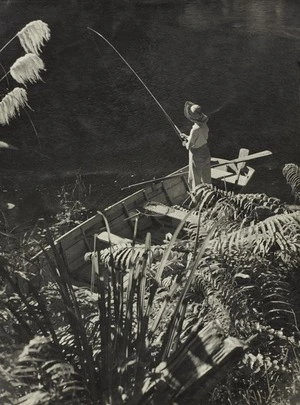 Woman trout fishing from a dinghy, Lake Waikaremoana
