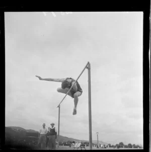 Athletic meeting, high jumper, clearing the bar, Petone Recreation Grounds, Wellington