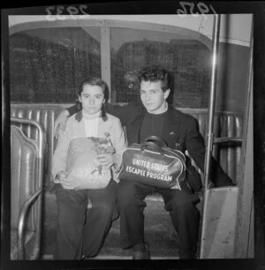 Hungarian refugees in a bus, a young man and a young woman, holding a bunch of flowers