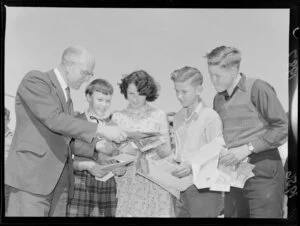 School teacher Mr L H Marchant with four unidentified children discussing proposed trip to Christchurch