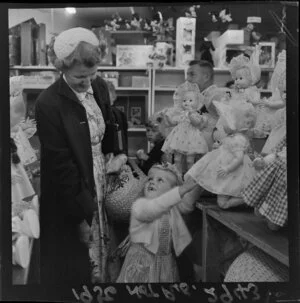 Christmas shoppers, unidentified woman and little girl,looking at a doll