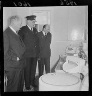Officials, including a high ranking policeman, inspect the laundry facilities at the Police Barracks on Vivian Street, Wellington