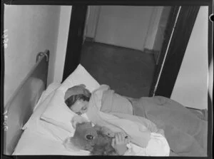 Dancer Pat Penrose, star of the Peep Show (the Oomph Girl), sleeping in bed with her soft toy koala