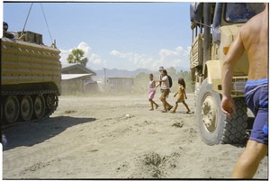 Army vehicles and people crossing a road, East Timor - Photograph taken by Kyle Harbour