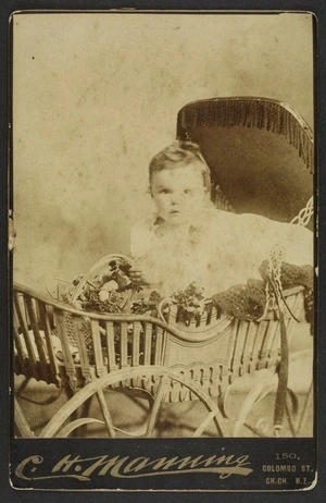 Manning, C H (Christchurch) fl 1880s-1890s :Portrait of unidentified child in wooden baby carriage (Perambulator)