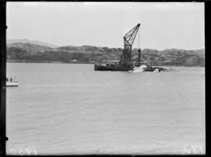 A Royal New Zealand Air Force Catalina flying boat with the floating crane Hikitia, Evans Bay, Wellington