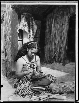 Maori girl weaving a food basket