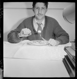 Man showing the incorrect way to hold a knife and fork