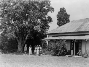 Treaty House at Waitangi with a group of people, including Lord and Lady Bledisloe, standing outside it