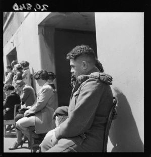 Sergeant C H Wickliffe of the Maori Battalion, listening to songs performed by children at Clyde Quay School, Wellington