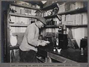 Herbert George Ponting working in the dark room of Scott's hut, Antarctica