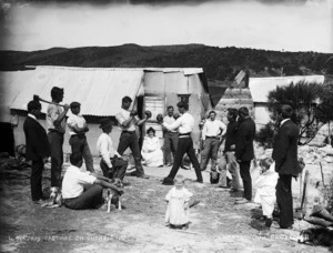 Group watching a boxing match on a gum field