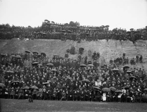 Part 2 of a 2 part panorama of spectators in the rain at Athletic Park, Wellington