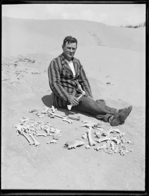 Man on beach with skeletal remains