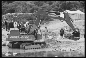 Earthmover lifting rocks from an unidentified river