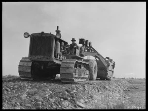 Unidentified man driving a heavy tractor, location unidentified