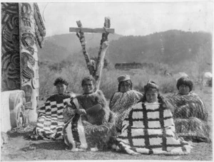Maori women wearing cloaks, outside Te Whai-a-te-Motu meeting house, Mataatua