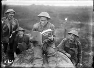 World War I New Zealander at the front reading a copy of 'New Zealand at the Front'