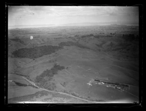 View of Kirkup's Farm with a road, farm buildings and rolling farmland, Auckland