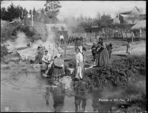 Women and children washing clothes in a hot pool, possibly at Whakarewarewa