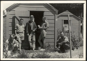 Five men outside a hut at a detention camp for conscientious objectors