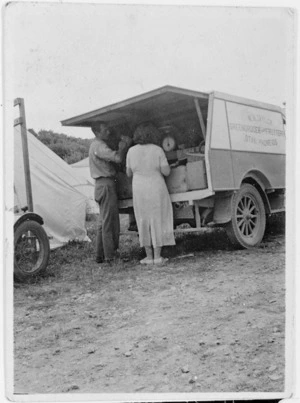 Two people at the back of a truck with produce from N N Taylor Greengrocer & Fruiterer, Otaki