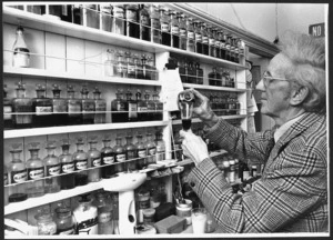 Pharmacist Ronald Castle preparing medicine at his shop on 139 Riddiford Street, Newtown, Wellington - Photograph taken by Jack Short