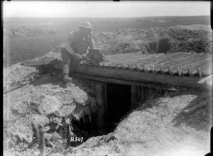 A signaller leaves his dugout on the Somme to work in the sunshine
