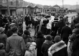 Crowd around a motorcar on its side